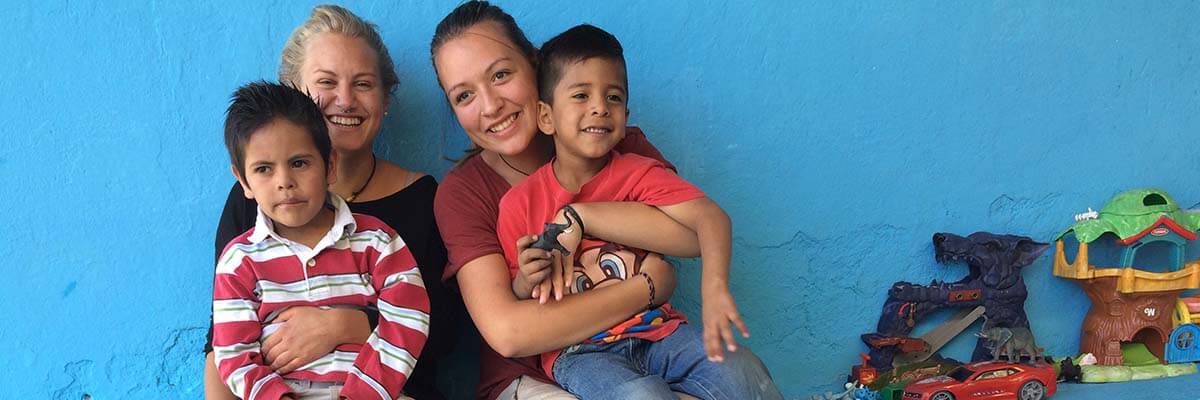 Freiwillige mit Kindern am Schoss