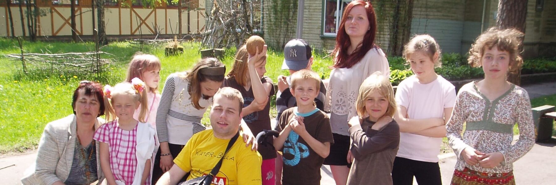 Freiwilliger im Rollstuhl in einer Gruppe von Kindern