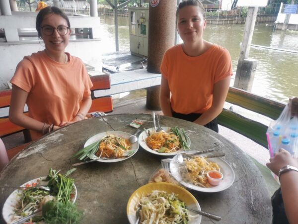 Volunteers (7) Zwei Freiwillige sitzen an einem Tisch beim Essen.