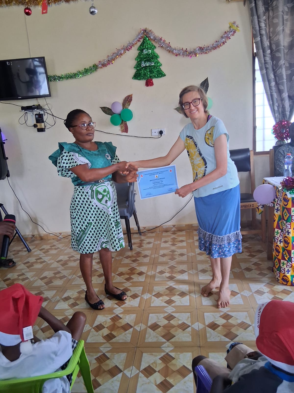 Foto Ghana Zertifikat Überreichung Foto von Christina Ott wie sie von einer Dame ein Zertifikat bekommt