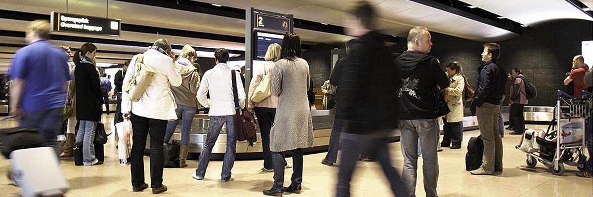 Gepäcksausgabeband am Flughafen wo Passagiere auf das Gepäck warten