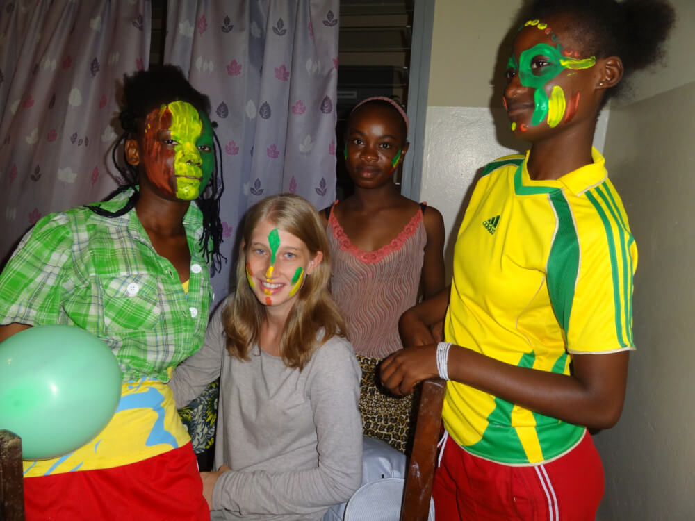 Vier junge Frauen haben sich mit den Farben der brasilianischen Fahne im Gesicht bemalt
