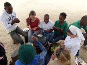 Jugendliche und eine Missionsschwester beim UNO Kartenspiel