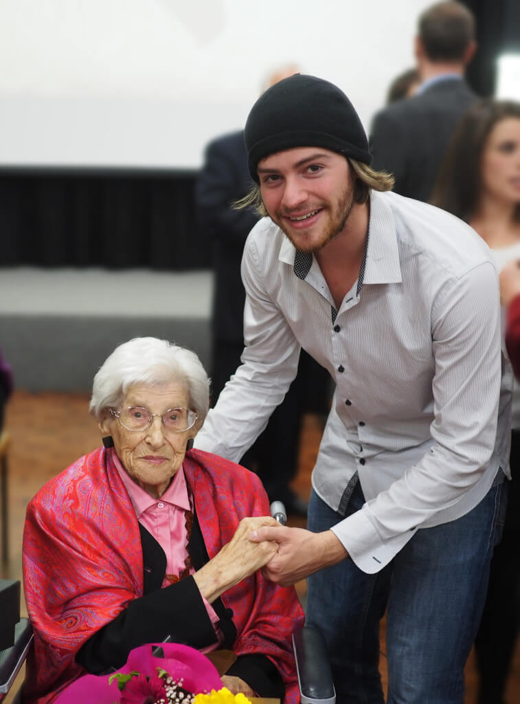 Ein Freiwilliger hält einer alten Frau die Hand