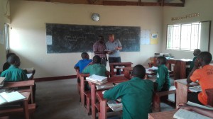 Zwei Männer stehen vor den Kindern in einer Schulklasse