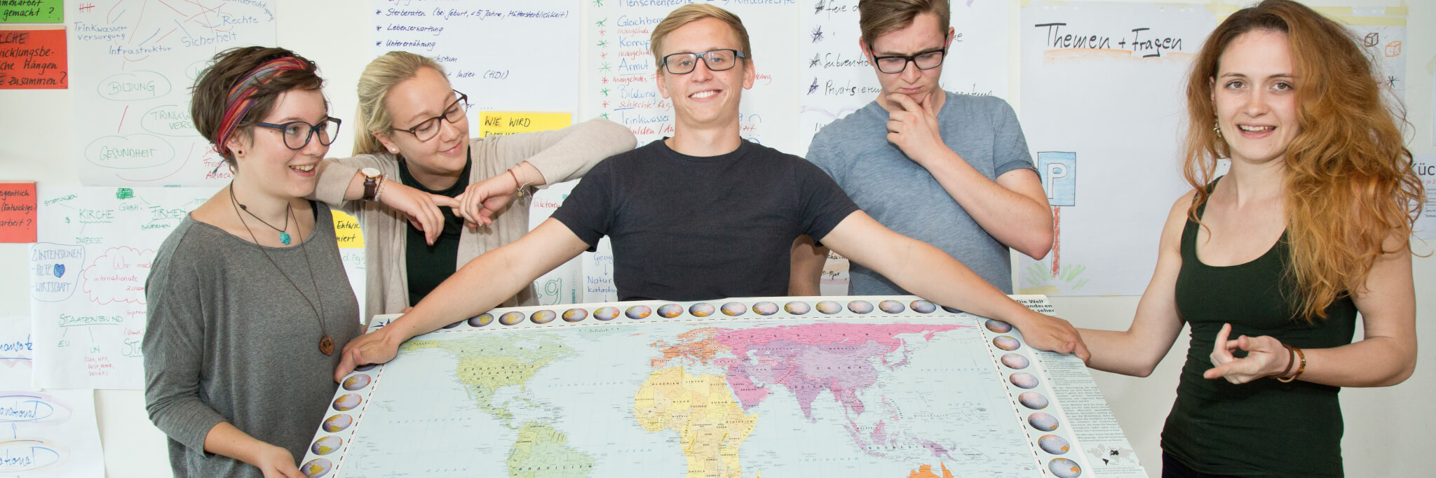 Bild: 4 Freiwillige halten eine Weltkarte