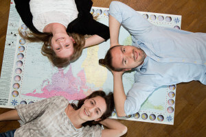 Drei Freiwillige liegen auf einer Weltkarte