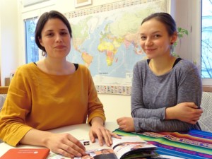 Zwei junge Frauen sitzen nebeneinander und haben Unterlagen vor sich liegen