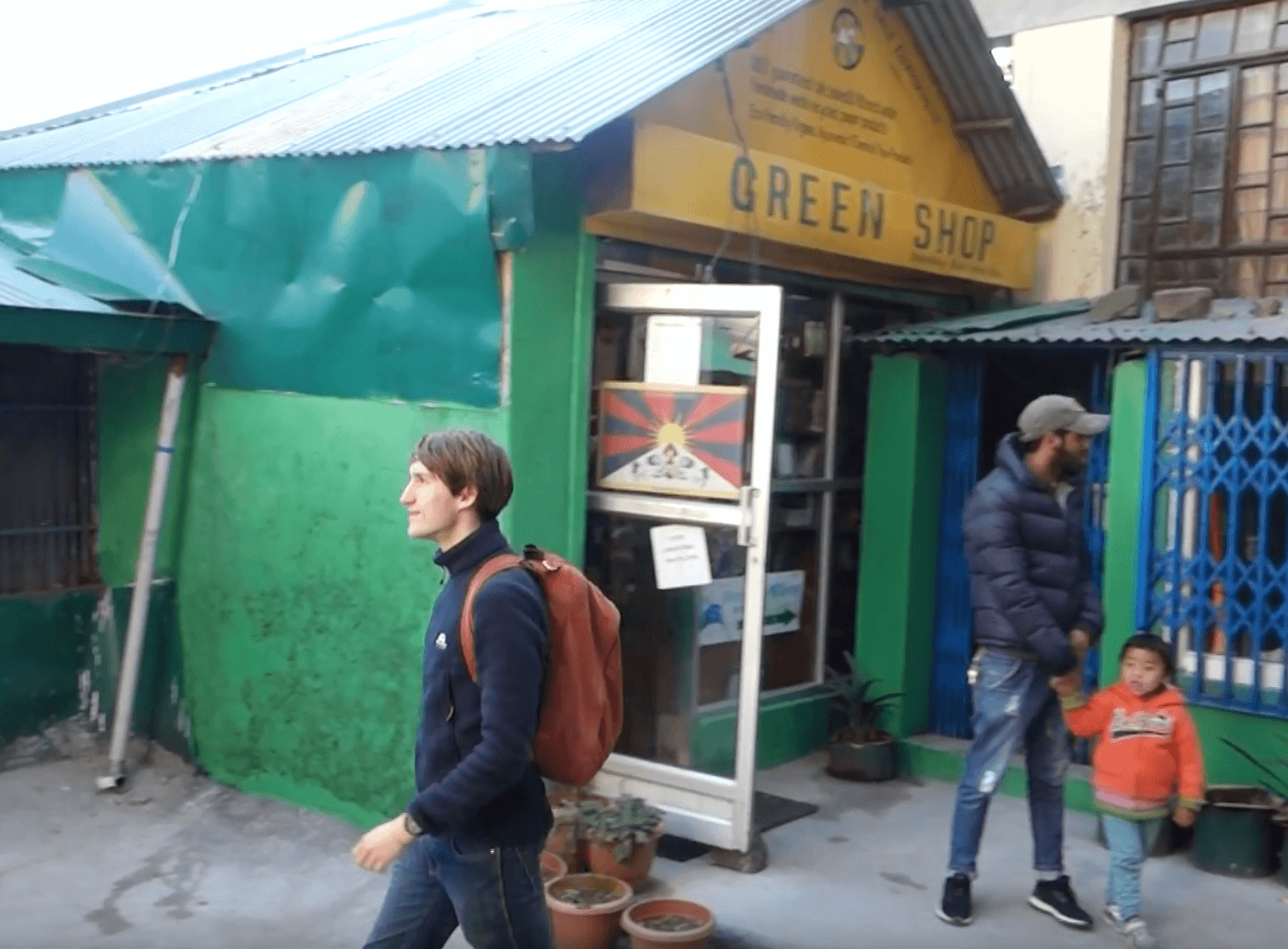 Freiwilliger spaziert vor "Green Shop"