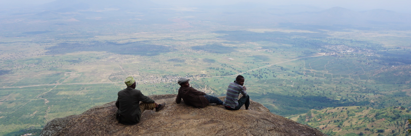 3 Männer sitzen auf Gipfel