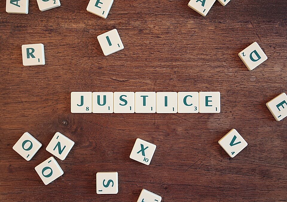 Mit Scrabble-Steinen ist das Wort "Justice" (deutsch: Gerechtigkeit) geformt